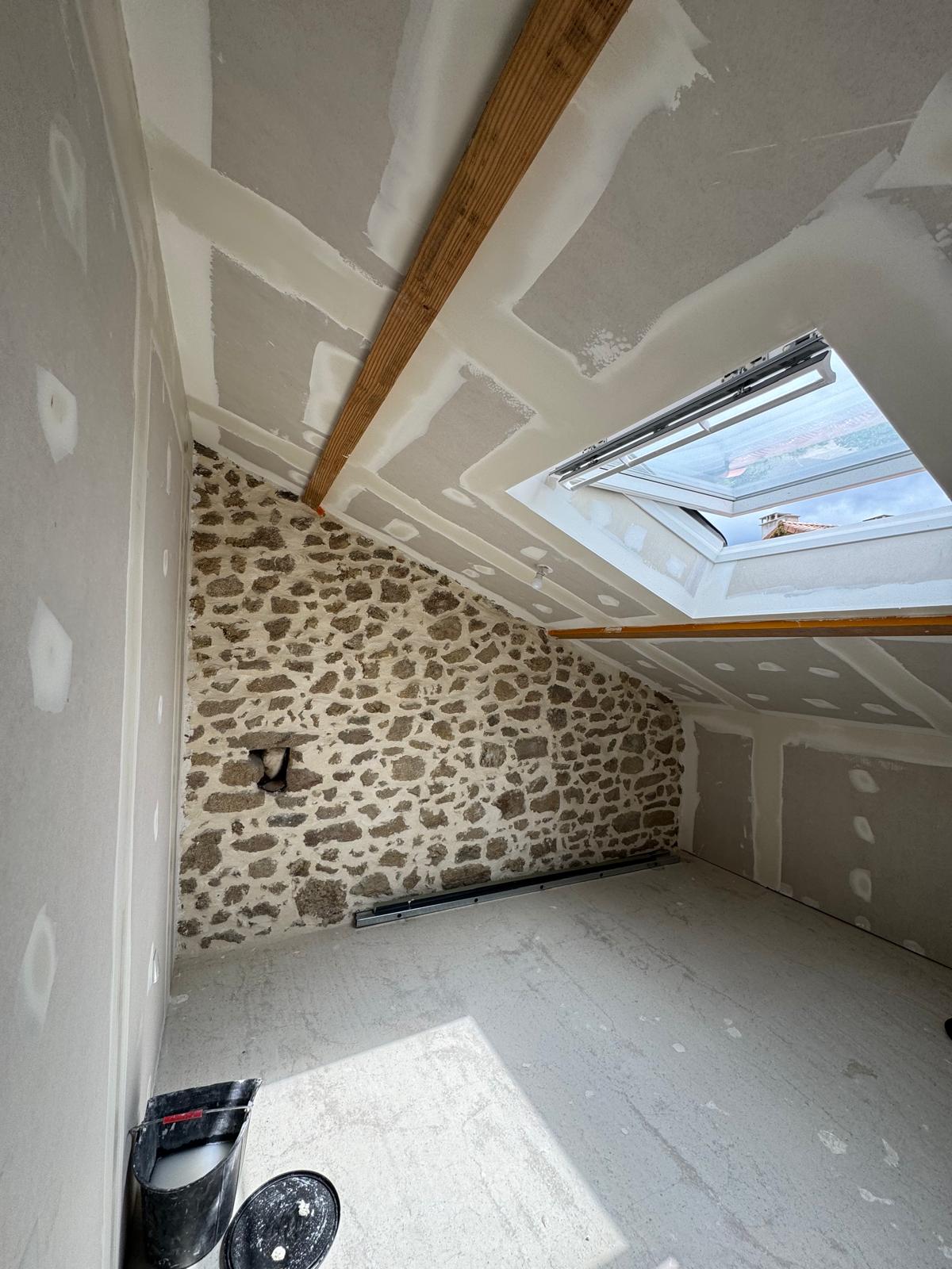 Combles aménagés avec mur en pierre et placo